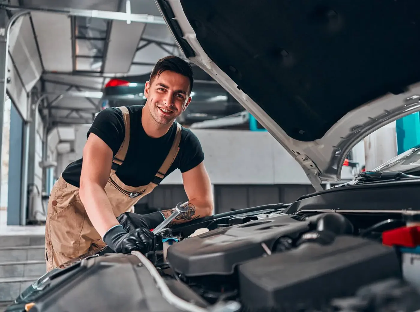 Technician working on a vehicle in an automotive repair workshop